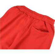 Detailed view of the red Sp5der Atlanta open leg sweatpants showing the elasticated waistband and pocket.