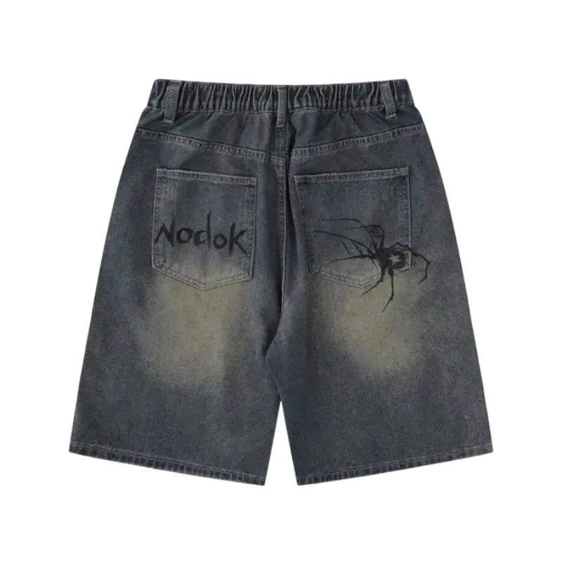 Back view of Sp5der print denim shorts featuring a dark wash, elastic waistband, and unique graphic spider designs.