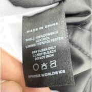 SP5DER Debossed Web Studded Leather Jacket material and care label showing cowskin leather and polyester lining.