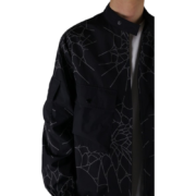 Close-up view of the black Sp5der Number Nine jacket featuring a distinctive grey spider web graphic pattern design.