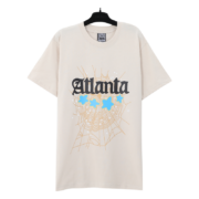 The Sp5der Young Thug Atlanta T-Shirt features a graphic design with a spider web and blue stars on a beige tee.