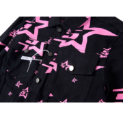Close-up of the black Sp5der 5 Star Trucker Jacket featuring a bold, vibrant pink star graphic pattern and silver buttons.