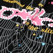 Close-up view of the Sp5der Web pink print t-shirt featuring intricate spider web graphics and yellow lettering detail.