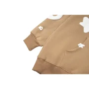 The Sp5der Beluga Hoodie in light-brown featuring a functional kangaroo pocket and signature distressed branding details.