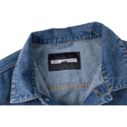 A close-up view of the branding label on the high-quality denim collar of the official SP5DER Worldwide Denim Jacket.