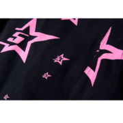 Detailed view of the pink Sp5der 5 Star graphic print featured on the black fabric of the iconic trucker jacket.