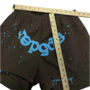 Sp5der OG Web Double Layer Shorts in black featuring the iconic blue web graphic and measuring tape for size reference.