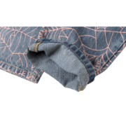 Close-up view of the folded hem detail on the Sp5der AOP Vintage 501 denim jeans featuring a pink spider web print.