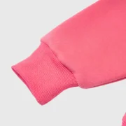 Close-up view of the ribbed sleeve cuff on the vibrant pink Sp5der Legacy streetwear hoodie in premium fleece.