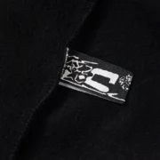 Detailed black label tag on the Sp5der Phantom Web hoodie, showing premium branding and high-quality fabric construction.