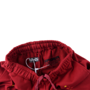 Close-up of the maroon SP5DER logo sweatpants featuring an elastic waistband and drawstring for a streetwear aesthetic.