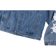 Close-up view of the SP5DER Worldwide denim jacket showcasing the signature sleeve graphic and high-quality denim.