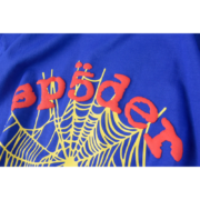 Royal blue Sp5der OG Web V2 t-shirt featuring the iconic yellow spider web graphic and bold red brand lettering.
