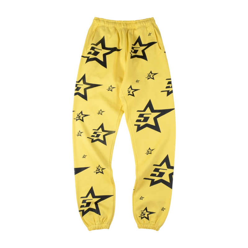 Front view of the vibrant yellow Sp5der 5Star sweatpants featuring a black star logo pattern throughout the design.