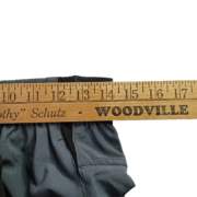Close-up view of a ruler measuring the waistband of the Sp5der Active TECH shorts to show precise sizing details.