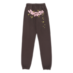 Front view of brown Sp5der OG Web sweatpants featuring pink branding and yellow star print on premium fabric.