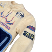 Close up of the Sp5der Worldwide Hunters Sherpa Moto Jacket featuring cream fleece and branded graphic patches.