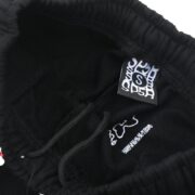 Detailed view of the Sp5der OG Web Sweatpants brand tag located inside the waistband for authenticity verification.