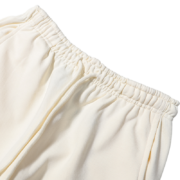 Close-up view of the elasticated waistband on the cream-colored Sp5der x Mariah the Scientist Scorpion sweatpants.