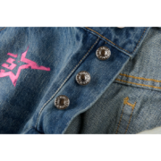 Close-up view of the button fly detail on Sp5der 5Star Vintage 501 Denim jeans with signature pink star graphic print.