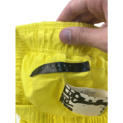 Close-up view of the interior yellow label and branding on a Sp5der OG Web Double Layer Short garment.
