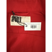 Sp5der Red Web Denim Cropped Trucker Jacket neck label and product barcode tag detail on vibrant red denim fabric