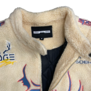 Close-up of the Sp5der Worldwide Hunters Sherpa Moto Jacket featuring the inner neck label and fleece texture detail.