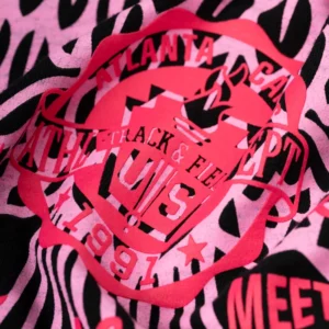 Close-up view of the vibrant pink Atlanta Track and Field graphic print on the black Sp5der Cross Country Slub Tee.