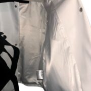Close-up view of the interior lining and label detailing of the premium white Roam The Halls Sp5der streetwear jacket.