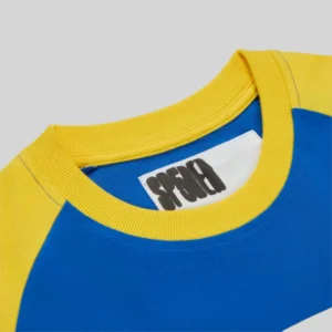 Close-up of the Sp5der 5uki Tee featuring a blue and yellow color-block design and signature graphic neck label.