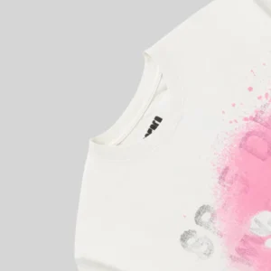 A close up look at the white Sp5der Standard Issue t-shirt featuring pink spray paint branding and graphic detail