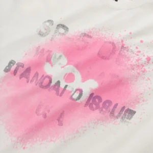 Close up of the Sp5der Standard Issue white t-shirt featuring a pink spray paint graphic design and bold lettering.