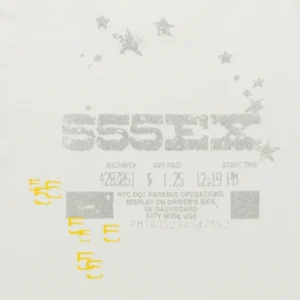 Close-up of the graphic print on a white Sp5der Anniversary Tee featuring a parking ticket design and silver stars.