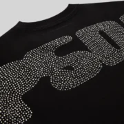 Close up view of the SP5DER logo on the back of the black rhinestone silk tee from the streetwear archive collection