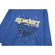 Close-up view of the Sp5der Acai Hoodie in navy blue, showcasing the unique spiderweb and star graphic print details.
