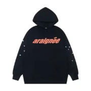 Front view of the Sp5der Araignee hoodie in black with orange logo text and white star sleeve graphic details.