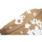 Close-up view of the sleeve graphic detail on the light-brown Sp5der Beluga Hoodie showing top-quality white print.