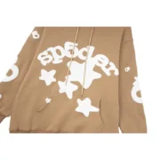Close-up view of the Sp5der Beluga Hoodie in light brown, highlighting the signature white graphic star design.