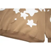 Light brown Sp5der Beluga hoodie featuring a kangaroo pocket and signature white star graphic print design.