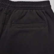 Close-up view of the 13oz cotton fleece fabric and waistband pocket detail on the Sp5der Big Star Black Sweatpants.