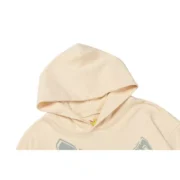 Close-up view of the Sp5der Cropped Hoodie in cream, featuring a high-quality cotton blend and urban design details.