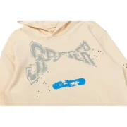 Close-up view of the Sp5der Cropped Hoodie in cream color showing the high-quality distressed logo print detail