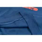 Close-up view of the premium fabric texture on the navy blue Sp5der cropped hoodie showing quality construction