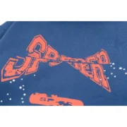 Close-up view of the Sp5der cropped hoodie in navy blue featuring a detailed distressed graphic print and star accents.