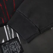 Close-up view of the black Sp5der Diffused Collegiate Crewneck featuring its signature graphic print and ribbed cuff.