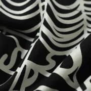 Close up view of the Sp5der Heavy Web Hoodie in black fabric featuring a detailed white signature web graphic print.