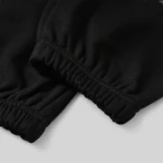 Close-up view of the elasticized cuffs on the premium black Sp5der Heavy Web sweatpants made of 13oz cotton fleece.