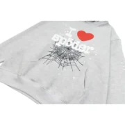 Sp5der I Heart SP5 Souvenir Hoodie in gray with a detailed close-up of the iconic red heart and spiderweb chest print.