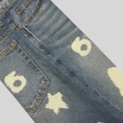A closeup view of the Sp5der Indigo Beluga Denim Short in blue featuring a distinct graphic print on the cotton fabric.