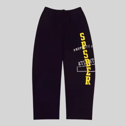 Front view of black Sp5der Issue 404 sweatpants featuring yellow vertical text and white graphic print details.